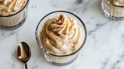 A close-up of a glass dish with soft banana puree and a tiny spoon.
