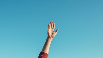 A person reaching out with an outstretched hand against a clear blue sky, symbolizing hope