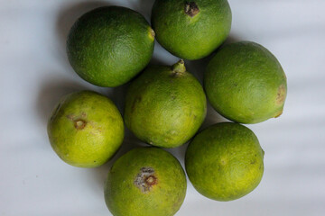 several whole limes on a white plate	