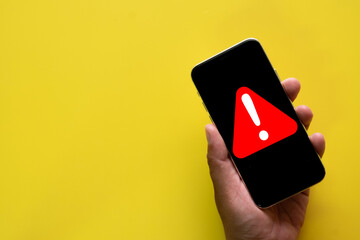Hand holding Smartphone with Red Exclamation Mark Warning Icon, Urgent Notification,Cyber Risk,Digital Safety,System Alert,System Error concept.