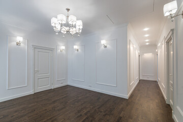 Fototapeta premium The corridor of a private house with white doors and walls. Parquet floor. Neoclassical style.