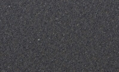 Close-up of dark textured sand surface