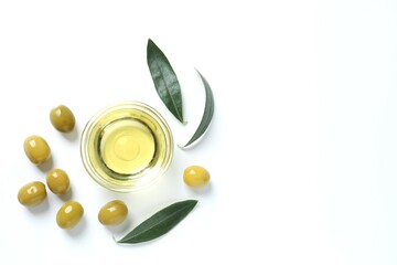 Bowl of fresh olive oil and olives with leaves on white background