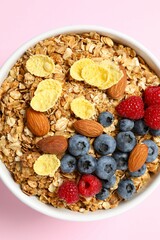 Delicious granola with berries on a color background