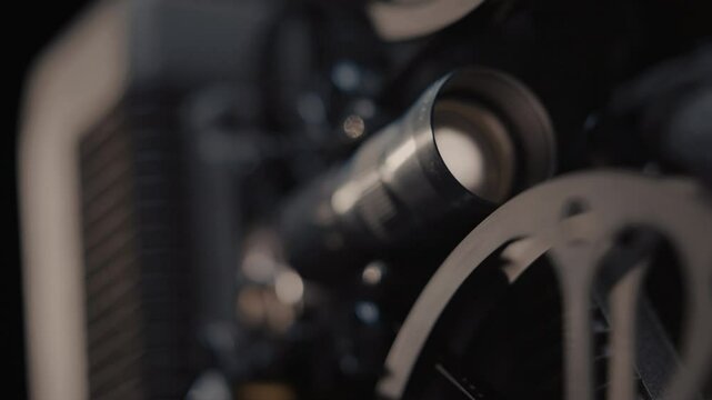 Close ups of a vintage 8MM projector spools moving and playing film 