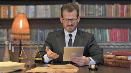 Middle Aged Lawyer with Loss on Tablet in Office