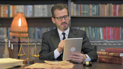 Middle Aged Lawyer Doing Video Chat on Tablet in Office