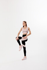 Fitness enthusiast demonstrates a balance exercise in a minimalist studio setting with bright lighting