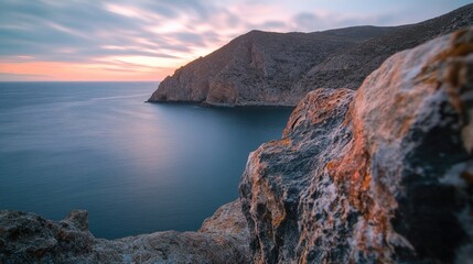 A cliff overlooking the ocean at sunset