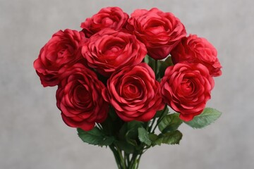 A bouquet of bright red roses arranged in a decorative vase, suitable for various occasions and decorative purposes