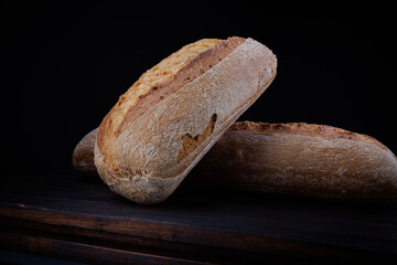 Two beautiful baguettes on a dark background. Art bread. Beautiful French baguette.
