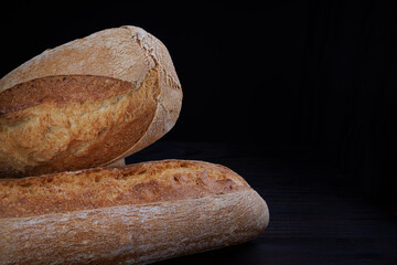 Two beautiful baguettes. Art bread. Beautiful French baguette on a dark background.