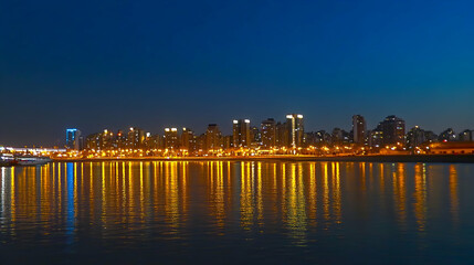 Obraz premium City Skyline at Night Reflecting on Water Building lights shine on the horizon for commercial use in travel or urban scenery concepts