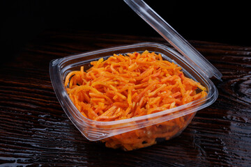 Korean spicy carrot salad in a plastic container. Korean carrot.