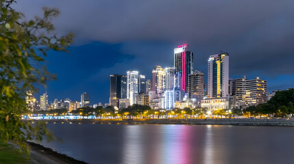 Fototapeta premium Illuminated cityscape at twilight. Night scene, colorful reflections on water for tourism, travel, architecture, or cityscape backgrounds