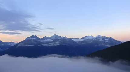 Mountains covered in snow peek out over the foggy valley at dawn. Use it for a travel magazine or tourism website