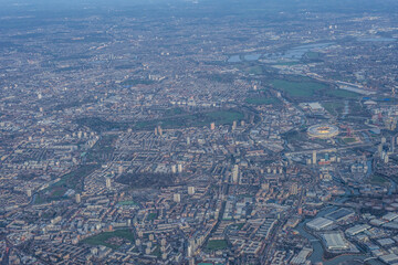 Aerial view of London through early morning clouds with Thames river flowing at golden hour sunrise near Tower Bridge