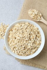 Composition with oatmeal flakes on gray background. Cooking breakfast
