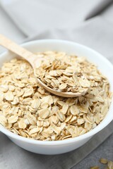 Composition with oatmeal flakes on gray background. Cooking breakfast
