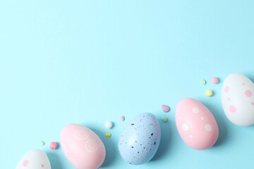 Happy Easter. Colorful eggs on a pastel blue background, space for text or advertising