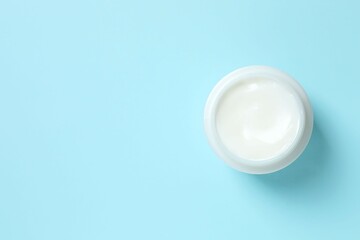 Cosmetic jar with moisturizing cream. Natural cosmetic products on a blue background, top view