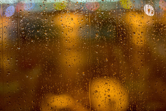 water drops on flass with lights in the background