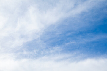 A vast expanse of Blue Sky adorned with wispy and delicate Clouds floats gracefully above