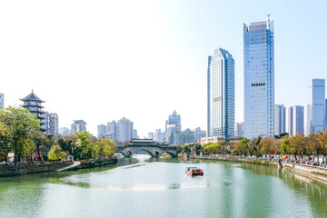 Beautiful and iconic cityscape view of tour boat about to cross the ancient Anshun Bridge on the...