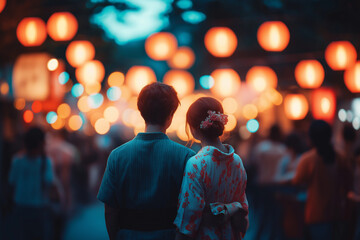 Fototapeta premium Zwei Personen in traditioneller Kleidung bei einem festlichen Abendmarkt