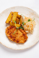 Savoring a Delicious Homemade Dish Featuring Crispy Chicken Cutlet, Golden Roasted Potatoes, and Fresh Coleslaw Presented on a Rustic Plate