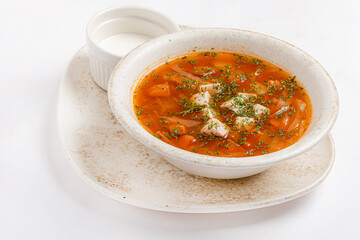 Warm and Comforting Bowl of Traditional Soup Garnished With Herbs, Served With a Side of Creamy Sauce on a Rustic Plate, Perfect for a Cozy Meal at Any Time of the Day