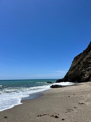 Tranquil Beach with Clear Blue Sky and Waves
