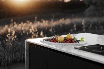Lemons, raspberries, and blueberries arranged on a marble countertop in a modern kitchen overlooking a blurred garden.