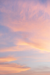 Dreamy pastel hues paint the sky at dusk, with wisps of clouds creating a delicate tapestry.