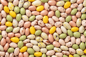 Easter abstract crowded background colorful pastel chocolate candy sweets as eggs. Food background. Religion tradition. Abstract pattern. View from above.