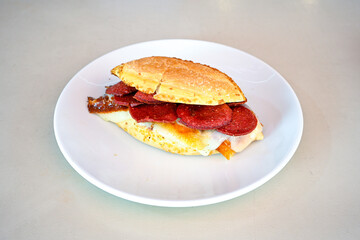 Close-up shot of Izmir's famous Turkish Traditional Kumru Sandwich, Ceşme Kumru, patso ingredients ready to eat salami, soudjouk, tomato, cheddar cheese and fried cheese. Yengen sandvic.