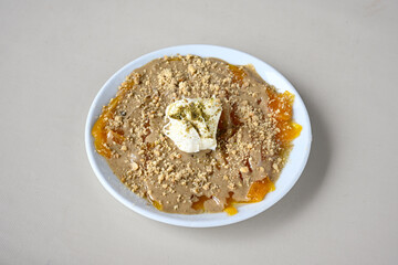 Pistachio kadayif on a plate. Turkish Dessert Kadayif with pistachio powder. Local name kaymakli  ekmek  kadayifi
