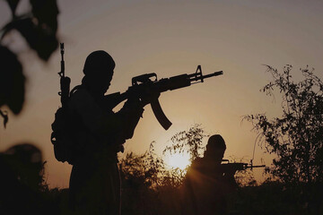 Obraz premium Terrorists in armed conflict at sunset