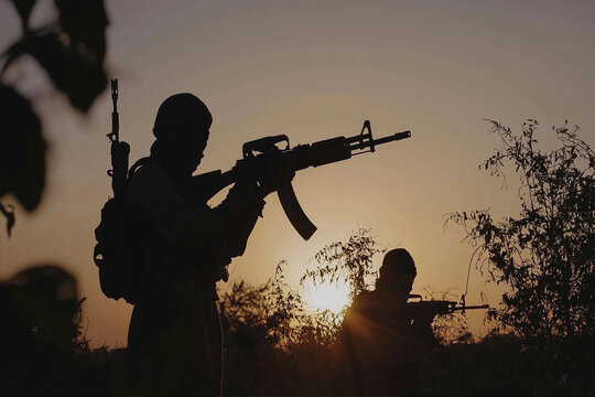 Terrorists in armed conflict at sunset
