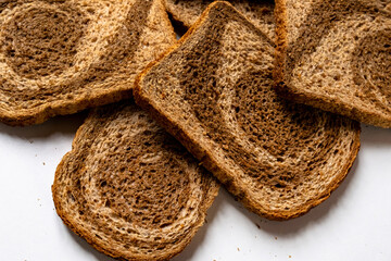 Slice ​​piece dark light bread dough twisted spiral white background coarse grinding