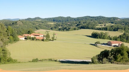 Fototapeta premium Scenic view of rolling hills and farmland under a clear blue sky.