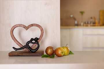 Heart-Shape Wooden Artistic Figurine and Couple Embracing on the kitchen table. Home Decor