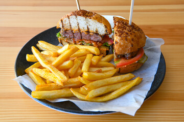 Big tasty burger with beef cutlet on a plate. Hamburger, cheeseburger with mushroom. Hamburger, Mexica, mushroom double burger.  Crispy chicken burger. With french fries, patates kizartmasi.