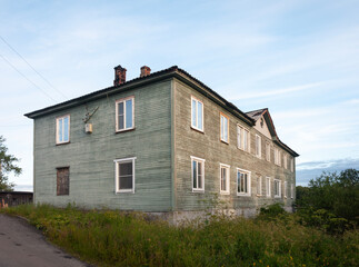 Obraz premium Old two-storey wooden house in northern Russian city of Belomorsk, Karelia. Summer evening