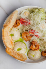 Fresh caesar salad featuring grilled chicken, crispy bacon, halved boiled eggs, crunchy croutons, parmesan cheese, and ripe cherry tomatoes in a white bowl. Restaurant or cafe menu, cookbook recipe