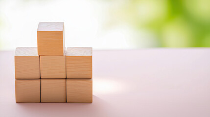 Obraz premium Stacking Wooden Blocks In A Steady Tower, Symbolizing Building A Strong Foundation For Future Stability, With Copy Space For Text.