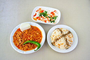 Turkish Etli Kuru Fasulye food with Traditional Turkish table with decoration. Nohut yemegi. Pilav ustu, kuru fasulye, nohut. Gunun menusu.