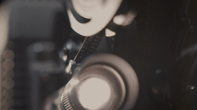 Close ups of a vintage 8MM projector spools moving and playing film 