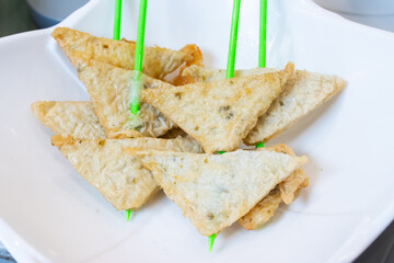 Fried tofu skin with seafood flavor are skewered on a green stick. Ready-made ingredients for shabu.