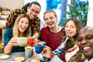 People group toasting latte at coffee bar restaurant hotel - Friends talking and having fun together with cute puppy at cappuccino bar - Alternative life style concept happy men, women and dog at cafe